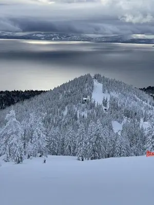 a mountain covered in snow with trees and water at Fantastic Lakeview house with large decks! in Incline Village