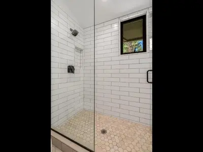 a shower with a glass door and a window at Modern Millcreek Home in Incline Village