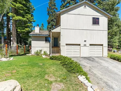 a white barn with two garage doors on a driveway at A great mountain home offering amenities that makes for a great getaway in Lake Tahoe in Incline Village