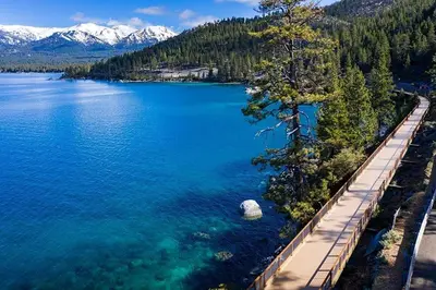 an aerial view of a lake with trees and a dock at The McCloud Condominium complex is one of the most popular vacation rentals in Incline Village