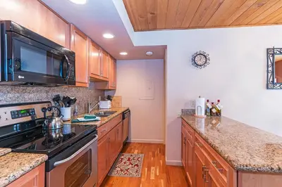 a kitchen with wooden cabinets and a stove top oven at Forest Pines Condo #216 in Incline Village