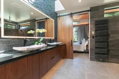 a bathroom with a sink and a large mirror at Elegance at Schaffer's Mill - Luxury 4 BR, Private Hot Tub, Pet Friendly! in Truckee