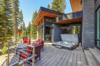 a deck with a hot tub and chairs on a house at Elegance at Schaffer's Mill - Luxury 4 BR, Private Hot Tub, Pet Friendly! in Truckee