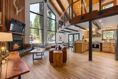 an open living room with a fireplace and a kitchen at Four Summits- Hot Tub- Pool Table- Short Drive to Ski Resorits in Carnelian Bay