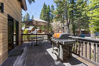 a grill on a deck with an umbrella at Four Summits- Hot Tub- Pool Table- Short Drive to Ski Resorits in Carnelian Bay