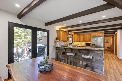 a kitchen with a wooden table and a large window at Four Summits- Hot Tub- Pool Table- Short Drive to Ski Resorits in Carnelian Bay