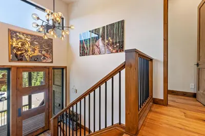 a staircase in a home with a chandelier at Harmony at Tahoe Donner - Ultra Modern 4 BR, Hot Tub, Game Room, Amenity Access in Truckee