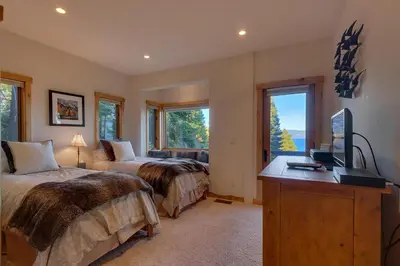 a bedroom with two beds and a desk with a television at Huckleberry Haven by Tahoe Getaways - Luxury Lake View 4BR in North Lake with Private Hot Tub in Carnelian Bay