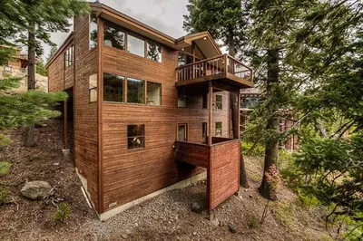 a wooden house in the middle of a forest at Juniper at Alpine - Private Hot tub, Pet Friendly & Free Shuttle to Slopes in Olympic Valley