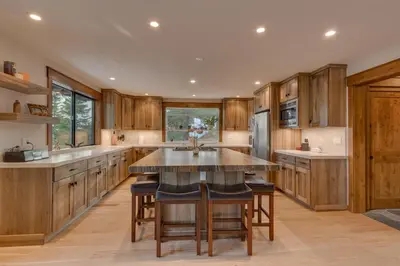 a kitchen with wooden cabinets and a large island at Kings Way Lake View by Tahoe Getaways - Spacious 4 BR w Private Hot Tub, Pool Table! in Tahoe Vista