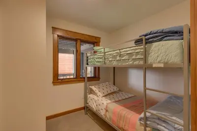 a bedroom with two bunk beds and a window at Kings Way Lake View by Tahoe Getaways - Spacious 4 BR w Private Hot Tub, Pool Table! in Tahoe Vista