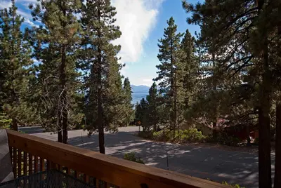 a wooden deck with a view of a road with trees at Lake Haven at Dollar Point - Spacious 4 BR w Lake Views, Sauna, Near Ski Resorts! in Tahoe City