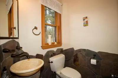 a bathroom with a toilet and a wooden sink at Look Out Lodge - On North Shore w Lake View, Hot Tub, Pool Table and Pet Friendly in Kings Beach