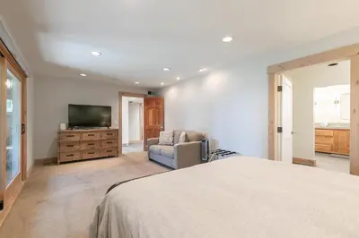 a bedroom with a bed and a tv and a couch at Lupine Lodge at Tahoe Park on the West Shore - Hot Tub, Beach Access, Near Ski Resorts! in Tahoe City