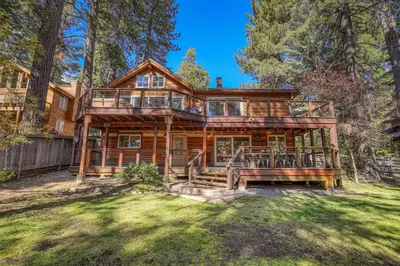 a large wooden house in the woods at Lupine Lodge at Tahoe Park on the West Shore - Hot Tub, Beach Access, Near Ski Resorts! in Tahoe City