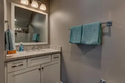 a bathroom with a sink and a mirror and towels at Mountain Jewel in Tahoe Donner - Beautiful 4 Bedroom w Hot tub, Access to HOA Amenities in Truckee