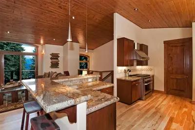 a kitchen with wooden ceilings and a kitchen with a counter at Rooney Ridge - Luxury 2600 Sq Ft, Cozy Fireplace, Family Room, Ping Pong Table! in Carnelian Bay