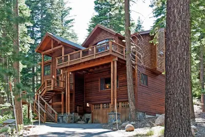 a log cabin in the woods with a tree at Rooney Ridge - Luxury 2600 Sq Ft, Cozy Fireplace, Family Room, Ping Pong Table! in Carnelian Bay