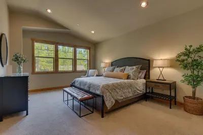 a bedroom with a bed and a table with a plant at Paradise in the Pines - Luxury Home in Quite Neighborhood, Wooded Views, Short Drive to Skiing in Carnelian Bay
