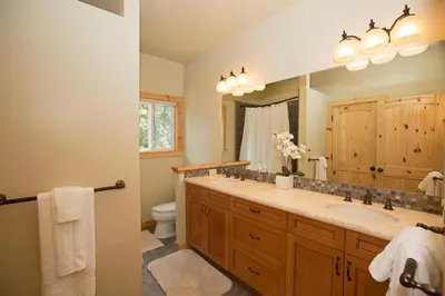 a bathroom with a sink and a toilet and a mirror at Sans Souci Terrace on the West Shore- 4 BR Cabin, Avail as a Ski Lease, Near Skiing! in Homewood