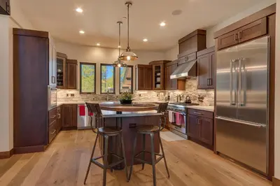 a kitchen with stainless steel appliances and wooden cabinets at Sage Hen at Grays Crossing - Gorgeous 4BR 4BA Home w Private Hot Tub in Truckee