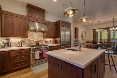 a kitchen with wooden cabinets and a stove top oven at Sage Hen at Grays Crossing - Gorgeous 4BR 4BA Home w Private Hot Tub in Truckee