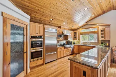 a kitchen with wooden cabinets and stainless steel appliances at Ski View at Tahoe Donner - Stunning 4 BR w Private Hot Tub - HOA Amenities in Truckee
