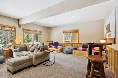 a living room with a couch and a table at Ski View at Tahoe Donner - Stunning 4 BR w Private Hot Tub - HOA Amenities in Truckee