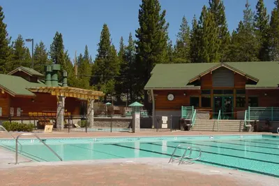 a large swimming pool in front of a lodge at Ski View at Tahoe Donner - Stunning 4 BR w Private Hot Tub - HOA Amenities in Truckee