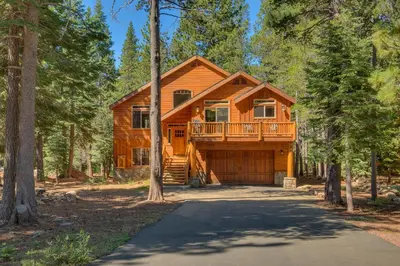 a log cabin in the woods with a driveway at Ski View at Tahoe Donner - Stunning 4 BR w Private Hot Tub - HOA Amenities in Truckee