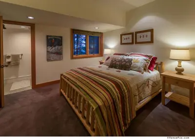 a bedroom with a bed and a table with a lamp at Skidder - Luxury 3500 sqft - Northstar 4BR w Game Room, Sauna, & HOA Amenities in Truckee