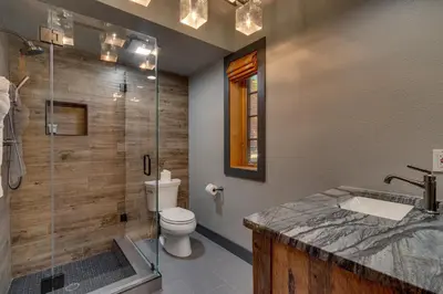 a bathroom with a shower and a toilet and a sink at Skidder - Luxury 3500 sqft - Northstar 4BR w Game Room, Sauna, & HOA Amenities in Truckee