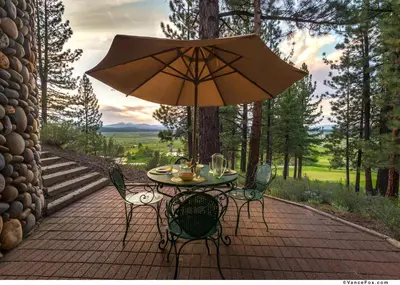a table and chairs with an umbrella on a patio at Skidder - Luxury 3500 sqft - Northstar 4BR w Game Room, Sauna, & HOA Amenities in Truckee