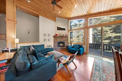 a living room with blue couches and a fireplace at Skislope Manor - Spacious Tahoe Donner 4 BR with Gorgeous Home Theater and Hot Tub in Truckee