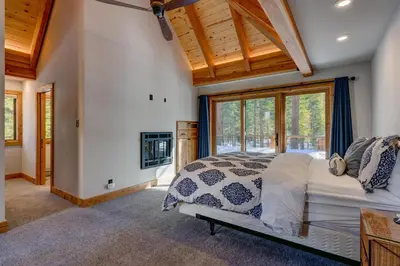 a bedroom with a bed and a large window at Snowbird Retreat at Northstar - Beautiful 4BR with Private Hot Tub, Free Ski Shuttle, HOA Amenities in Truckee