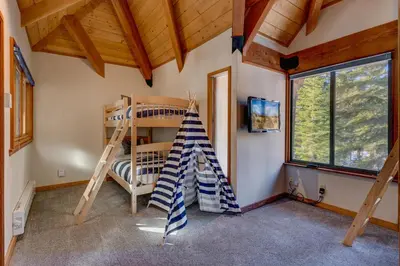 a room with a bunk bed and a ladder at Snowbird Retreat at Northstar - Beautiful 4BR with Private Hot Tub, Free Ski Shuttle, HOA Amenities in Truckee