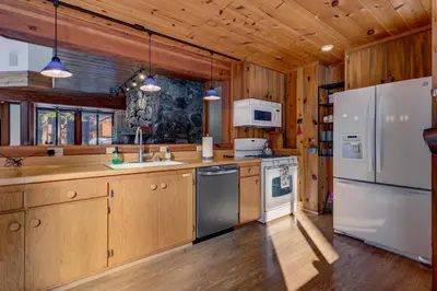 a kitchen with wooden cabinets and white appliances at Snowbird Retreat at Northstar - Beautiful 4BR with Private Hot Tub, Free Ski Shuttle, HOA Amenities in Truckee