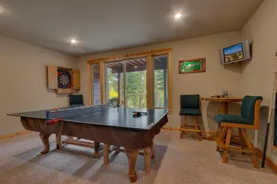 a room with a ping pong table and two chairs at High Altitude at Tahoe Donner - Huge 4 BR with Private Hot Tub, Pool Table, Ping Pong, HOA Amenities in Truckee