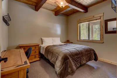 a bedroom with a bed and a desk and a window at Edelweiss Retreat- Close to Lake and Ski Resorts- Pet Friendly- Hot Tub in Tahoe City