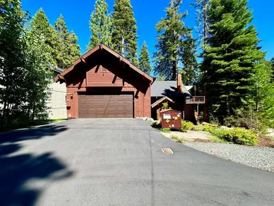 a building with a garage with a driveway at Edelweiss Retreat- Close to Lake and Ski Resorts- Pet Friendly- Hot Tub in Tahoe City