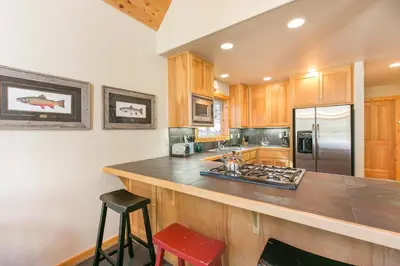 a kitchen with a counter top and a refrigerator at Interlaken on the West Shore by Tahoe Getaways - Pet Friendly 3BR, Close to Skiing & Walk to the Lake! in Homewood