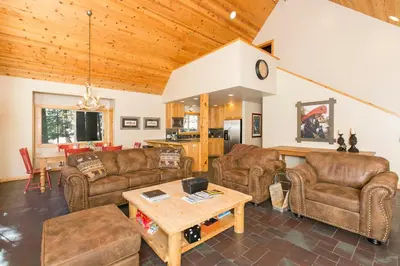 a living room with leather couches and a table at Interlaken on the West Shore by Tahoe Getaways - Pet Friendly 3BR, Close to Skiing & Walk to the Lake! in Homewood