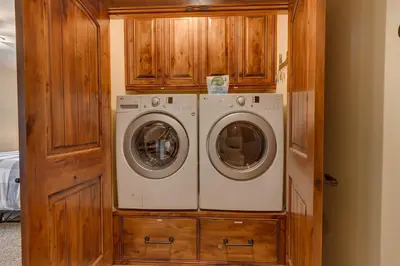 a washer and dryer in a wooden cabinet at Hawk's Peak at Tahoe Donner in Truckee