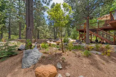 a house in the woods with a deck and trees at Hawk's Peak at Tahoe Donner in Truckee