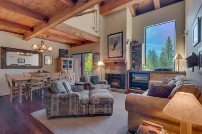a living room with a couch and a table and a fireplace at North Shore Lakeside Condo #8 by Tahoe Getaways - Updated 3 Story Condo Near Palisades Resort w HOA! in Tahoe City