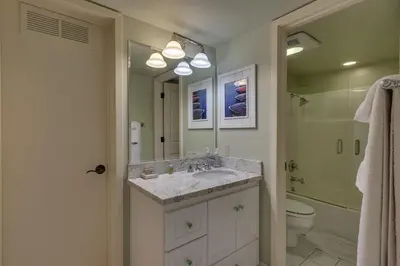 a bathroom with a sink and a toilet and a mirror at North Shore Lakeside Condo #8 by Tahoe Getaways - Updated 3 Story Condo Near Palisades Resort w HOA! in Tahoe City
