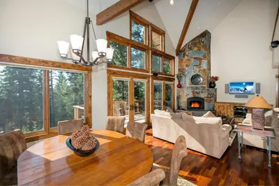 a living room with a table and a fireplace at North Shore Bliss by Tahoe Getaways - 3 BR plus loft & Private Hot Tub in Carnelian Bay