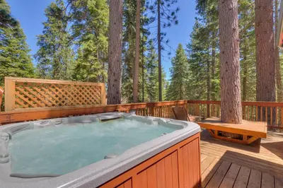 a hot tub on a deck in the woods at Piney wood - Quiet 2 BR Loft w Private Hot Tub in Carnelian Bay