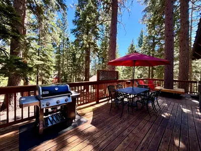 a deck with a grill and a table and chairs at Piney wood - Quiet 2 BR Loft w Private Hot Tub in Carnelian Bay