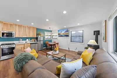 a living room with a couch and a kitchen at Sandy Cove on the North Shore -Lakeside Cottage with Pier Beach, and HOA Amenities in Tahoe Vista